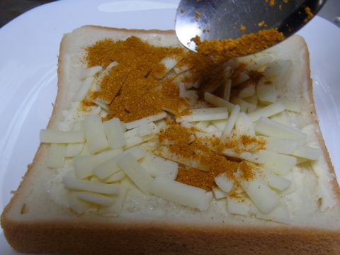 チーズの上にカレー粉をかけます。